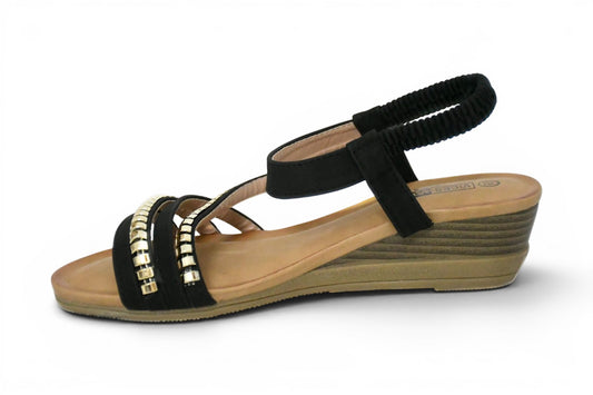 calzado de verano de talla grande para mujer de color negro y diseño de tiras en el empeine con decoración de tachuelas doradas, cuña baja y agarre elástico al tobillo