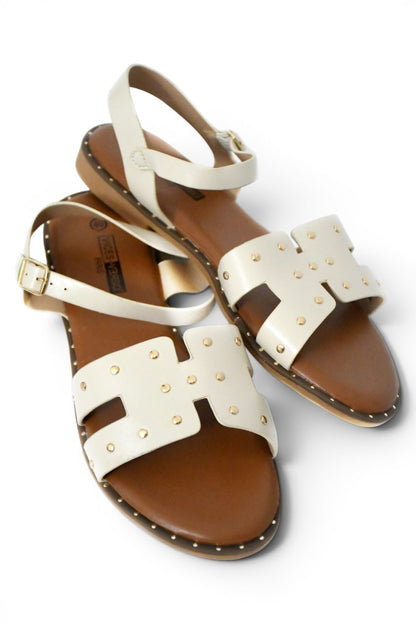 sandalia de talla grande para mujer en color beige y decorada con pequeñas tachuelas doradas, suela en tono cuero y plana