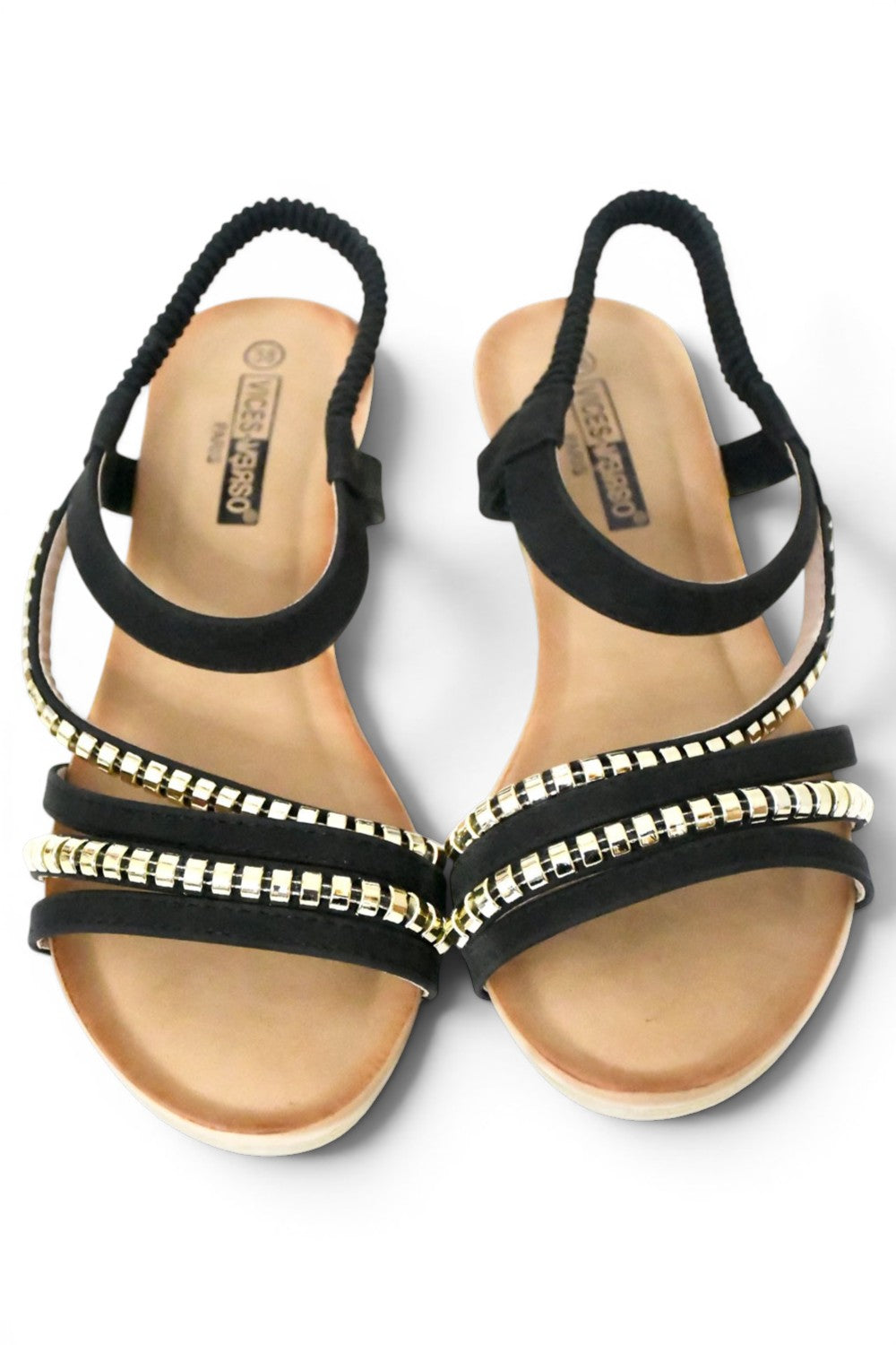 sandalia de talla grande para mujer de color negro y diseño de tiras en el empeine decoradas con tachuelas doradas y el agarre al tobillo elástico, cuña y suela acolchada