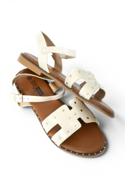 sandalia de verano de color beige y tachuelas doradas con agarre al tobillo y suela plana de talla 43